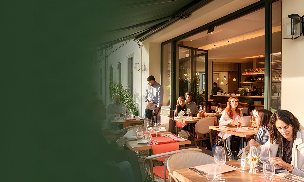 Belebte Terrasse eines Freiburger Restaurants neben einem ruhigen Gastraum in der Nebensaison